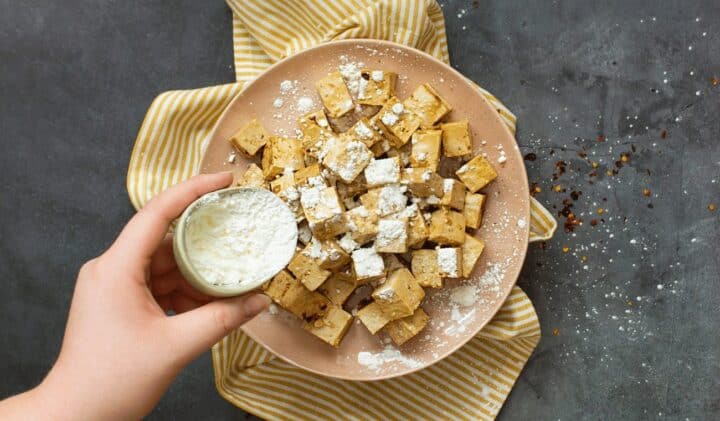 Tofu pyöritetään maissitärkkelyksessä ja paistetaan rapeaksi.